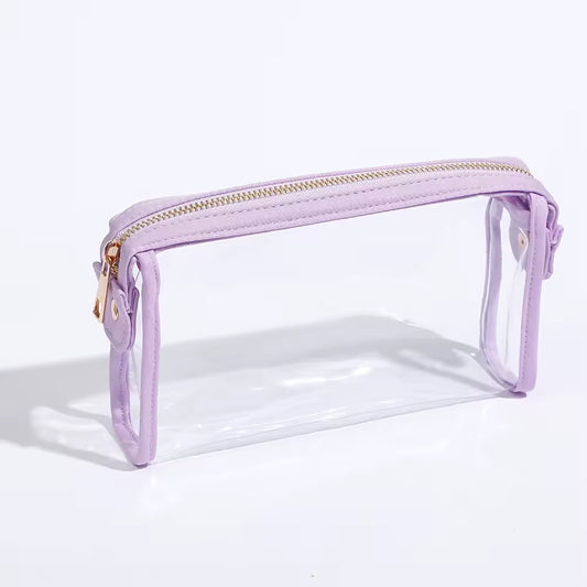 Clear pouch cosmetic bag with purple border and gold zipper on a white background